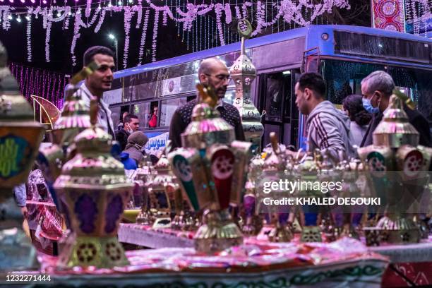 People walk past a stall selling Ramadan lanterns along a main street in the northern suburb of Shubra of Egypt's capital Cairo on April 12 at the...