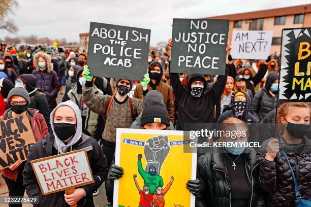 People gather holding signs before curfew to protest the death of Daunte Wright who was shot and killed by a police officer in Brooklyn Center,...