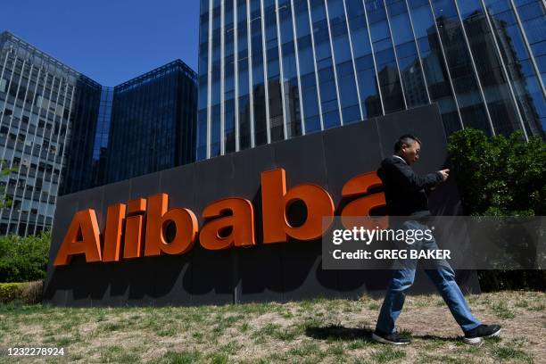 Man walks past an Alibaba sign outside the company's office in Beijing on April 13, 2021.