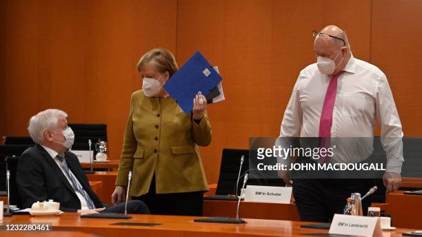 German Economy Minister Peter Altmaier looks on as German Chancellor Angela Merkel talks with German Interior Minister Horst Seehofer as she arrives...
