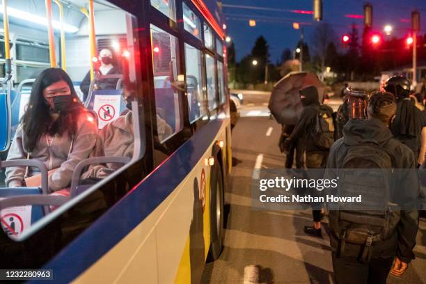 Commuter watches from inside a bus as activists march during a protest against the killing of Daunte Wright on April 12, 2021 in Portland, Oregon....