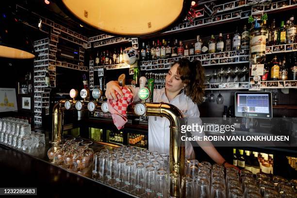 Barmaid cleans a beer tap during preparations at Cafe Ubica, which has taken several precautions ahead of its temporary Fieldlab reopening in Utrecht...