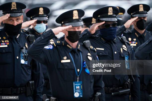 Police officers salute the casket containing the remains of late U.S. Capitol Police officer William Evans as it is carried into the U.S. Capitol to...