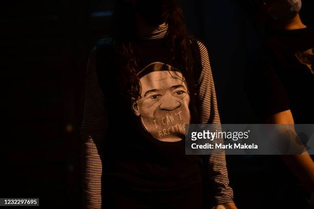 An activist wears a t-shirt depicting George Floyd during a march to protest the death of Daunte Wright on April 13, 2021 in Philadelphia,...