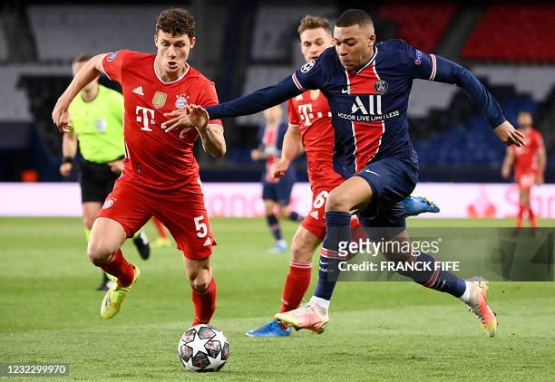 Paris Saint-Germain's French forward Kylian Mbappe fights for the ball with Bayern Munich's defender Benjamin Pavard during the UEFA Champions League...