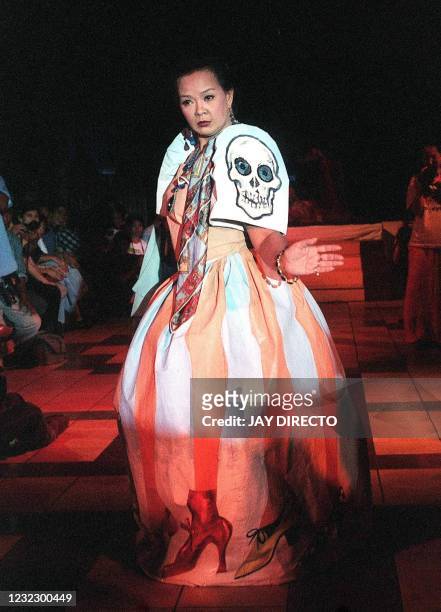 Model mimicking former Philippines first lady Imelda Marcos, struts on the catwalk clad in a caricature of a traditional Filipino "terno" dress...