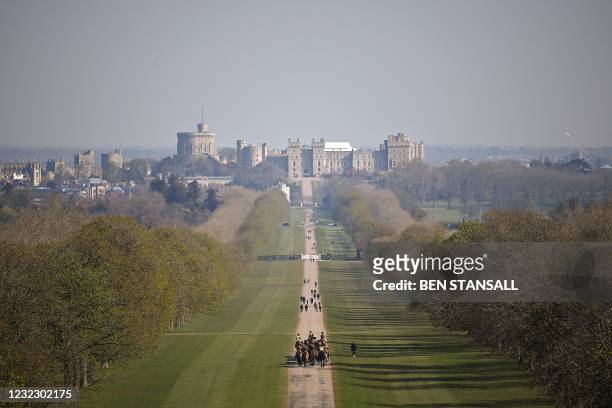 Mounted regiment of the British Army exercise their horses along The Long Walk, leading to Windsor Castle in Windsor Great Park, west of London, on...
