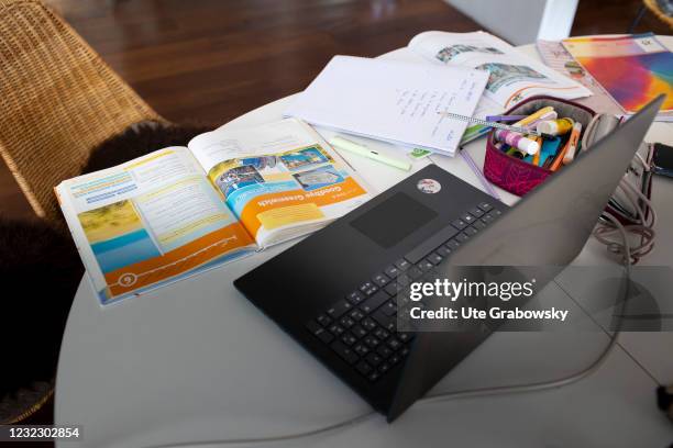 Bonn, Germany In this photo illustration a laptop and a schoolbook on a table after homeschooling on April 14, 2021 in Bonn, Germany.