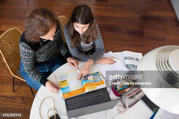 Bonn, Germany In this photo illustration a girl and a woman are sitting at a table doing homework in times of corona lockdown on April 14, 2021 in...