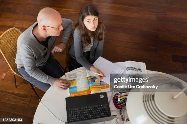 Bonn, Germany In this photo illustration a girl and a man are sitting in front of a laptop on April 14, 2021 in Bonn, Germany.