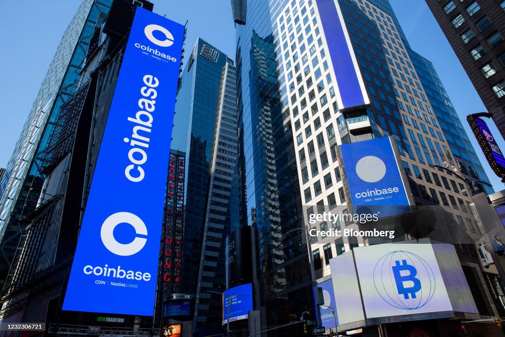 Monitors display Coinbase signage during the company's initial public