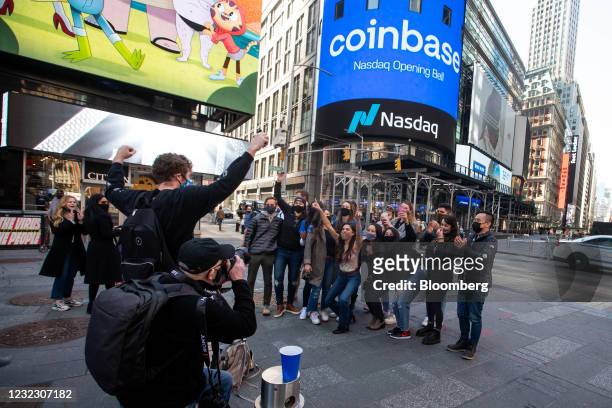 Coinbase employees gather for a group photo during the company's initial public offering outside the Nasdaq MarketSite in New York, U.S., on...