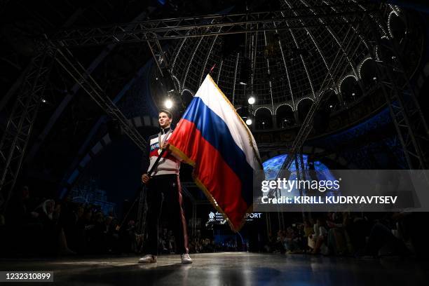 Model holding a Russian flag presents the Russian Olympic Team uniform for the Tokyo 2020 Olympic Games, designed and manufactured by ZASPORT...