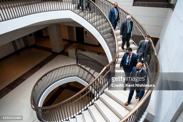 Director William Burns, surrounded by staff and security walks down stairs after testifying at a Senate Select Committee on Intelligence hearing...