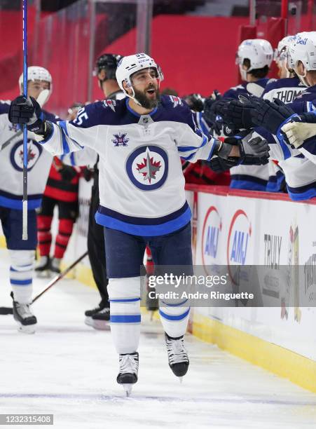 Mathieu Perreault of the Winnipeg Jets celebrates his third period goal against the Ottawa Senators with teammates at the players bench at Canadian...