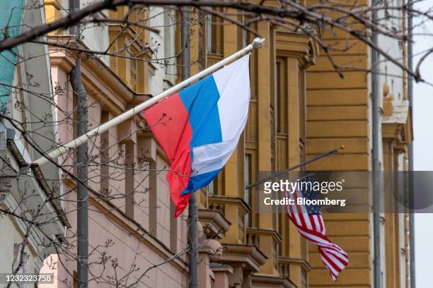 Russian national flag, left, and an American flag in front of the U.S. Embassy building in Moscow, Russia, on Thursday, April 15, 2021. The Biden...