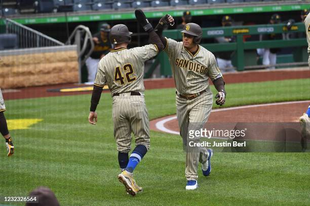 Manny Machado of the San Diego Padres celebrates with Jake Cronenworth after hitting a two run home run in the first inning during the game against...