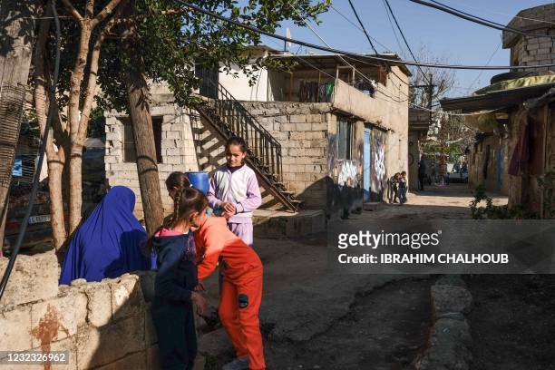Children play in an alley in the Ghoraba cemetery, named after the neighbourhood where it is situated in Lebanon's northern port city of Tripoli on...