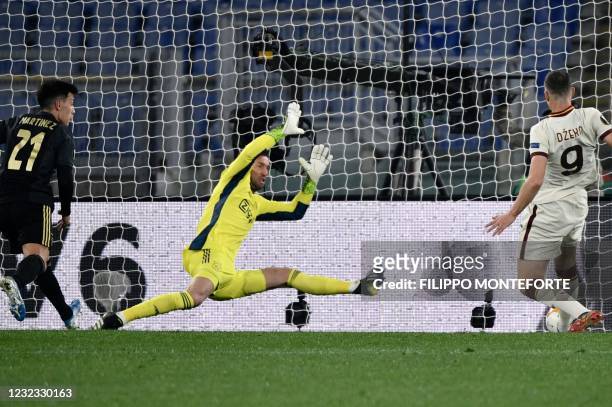 Roma's Bosnian forward Edin Dzeko scores an equalizer past Ajax Dutch goalkeeper Maarten Stekelenburg during the UEFA Europa League quarter final...