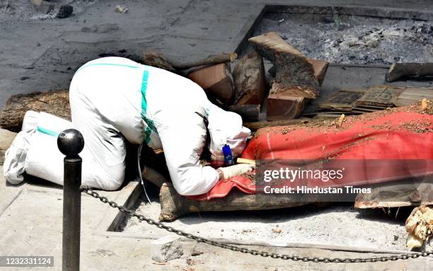 Relatives of a person who died of Covid-19 perform the last rites during cremation at Nigambodh Ghat Crematorium on April 15, 2021 in New Delhi,...