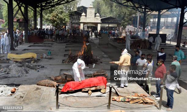Relatives of a person who died of Covid-19 perform the last rites during cremation at Nigambodh Ghat Crematorium on April 15, 2021 in New Delhi,...