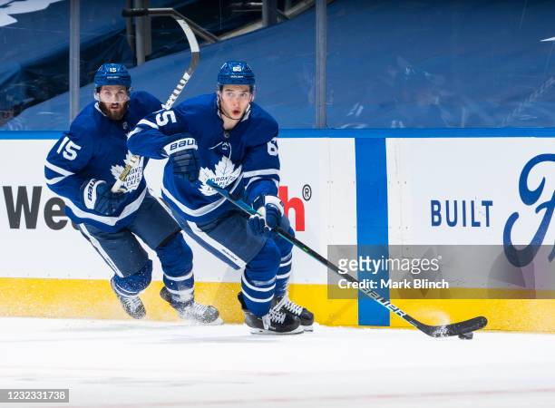 Ilya Mikheyev of the Toronto Maple Leafs plays the puck against the Winnipeg Jets as teammate Alexander Kerfoot skates during the first period at the...