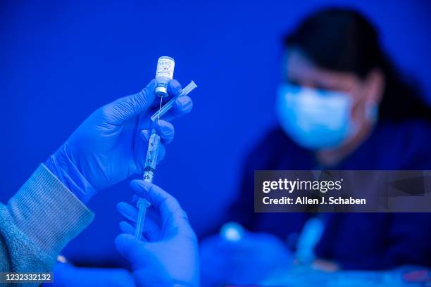 Los Angeles, CA Medical professionals load syringes with Pfizer and Moderna COVID-19 vaccines before giving them to people on the first day that...