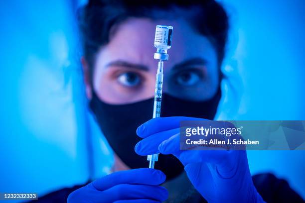 Los Angeles, CA Liesl Eibschutz, a medical student from Dartmouth University, loads a syringe with Pfizer COVID-19 vaccine before giving it to people...