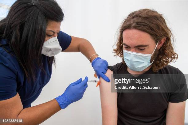 Los Angeles, CA Nurse Andrea Delacueva, left, gives a COVID-19 vaccination to Matt Block of Culver City, at Kedren Health on Thursday, April 15, 2021...