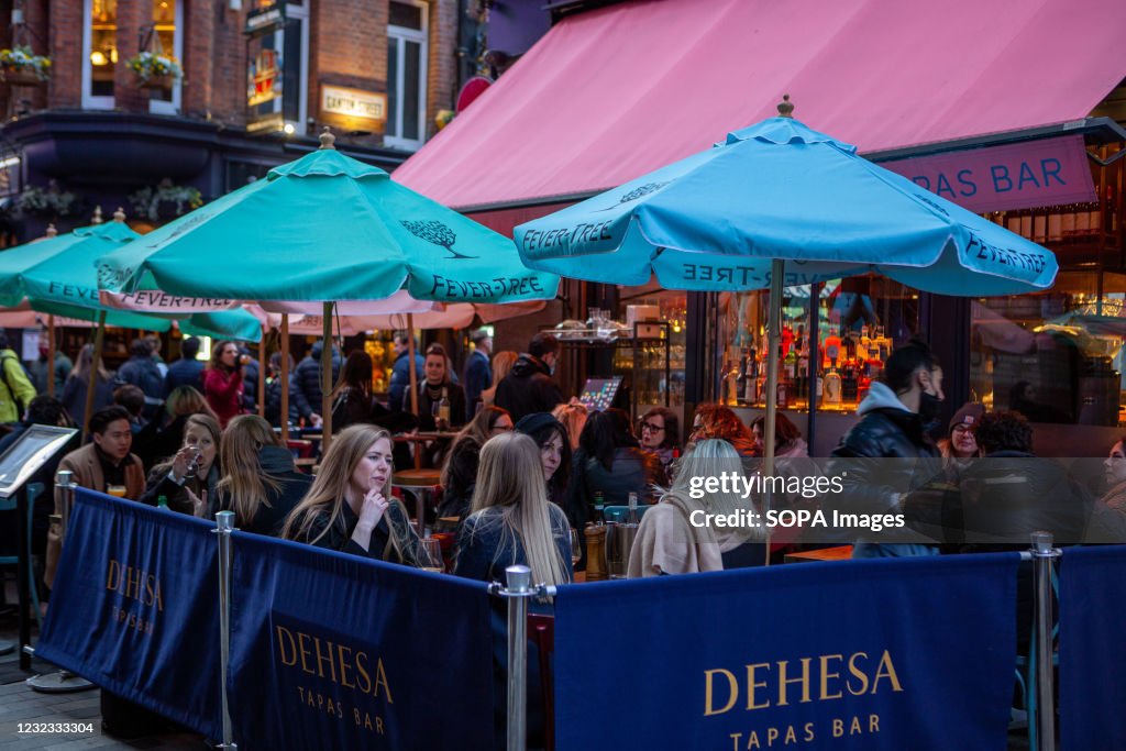 People enjoying food and drinks in Carnaby Street area.
As...