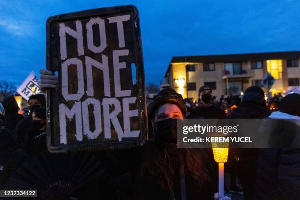 Demonstrators hold candles and signs as they protest peacefully ahead of the 10pm curfew, in front of the Brooklyn Central Police Station in Brooklyn...