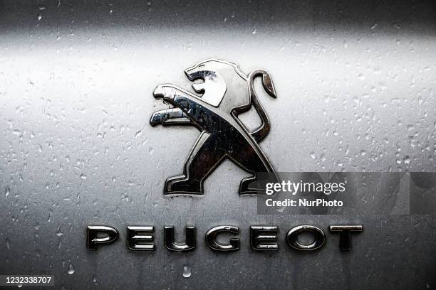 Peugeot car emblem is covered with raindrops. Krakow, Poland on April 16, 2021