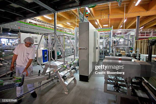 An employee collects packets of newly-manufactured "Nestogen" baby food supplement on the conveyor belt at Nestle's production unit for probiotic...