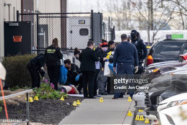 Group of crime scene investigators gather around a body in the parking lot of a FedEx SmartPost on April 16, 2021 in Indianapolis, Indiana. The area...