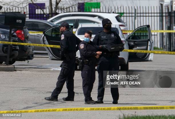 Police officers stand guard outside the site of a mass shooting at a FedEx facility in Indianapolis, Indiana on April 16, 2021. - A gunman has killed...