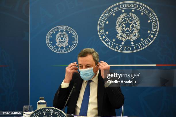 Italian Prime Minister Mario Draghi removes his face mask during a press conference on COVID-19 restrictions to be gradually eased from April 26th,...