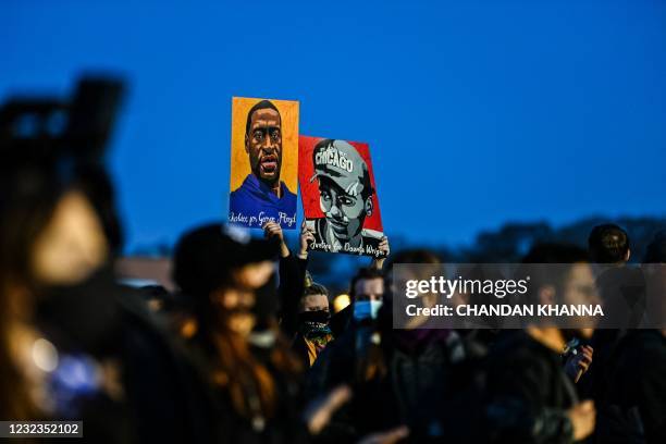 Demonstrators hold George Floyd and Daunte Wright's portraits during the sixth night of protests over the shooting death of Daunte Wright by a police...