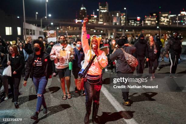 Protesters March along the Hawthorne Bridge following the police shooting of a homeless man in Lents Park on April 16, 2021 in Portland, Oregon. The...