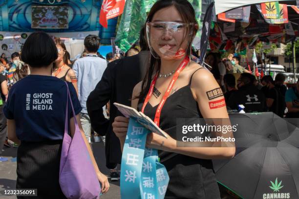 Hostess of the event ''2021 Stand for Weed Taipei'' welcoming the guests and distributing gifs like stickers and other products related to the event...