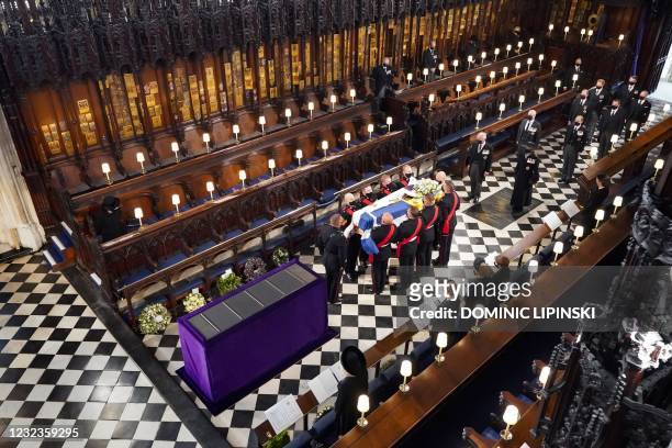 Queen Elizabeth II watches as pallbearers carry the coffin of Britain's Prince Philip, Duke of Edinburgh during his funeral inside St George's Chapel...