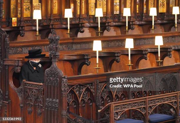 Queen Elizabeth II takes her seat during the funeral of Prince Philip, Duke of Edinburgh in St George's Chapel at Windsor Castle on April 17, 2021 in...