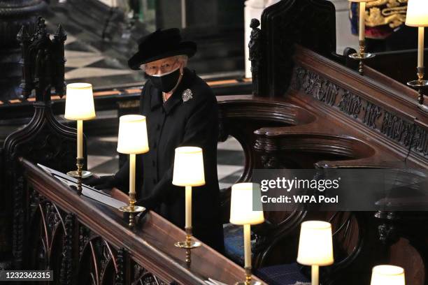 Queen Elizabeth II watches as pallbearers carry the coffin of Prince Philip, Duke Of Edinburgh into St George’s Chapel by the pallbearers during the...