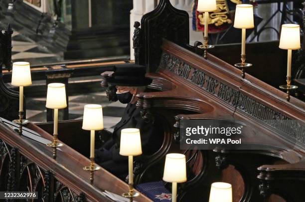 Queen Elizabeth II watches as pallbearers carry the coffin of Prince Philip, Duke Of Edinburgh into St George’s Chapel by the pallbearers during the...