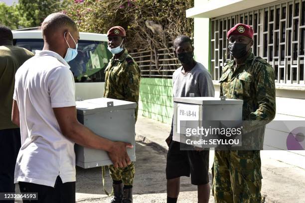 Military personnels carry ballot boxes and voting equipment to a polling station in Praia, on April 17 on the eve of the parliamentary elections.