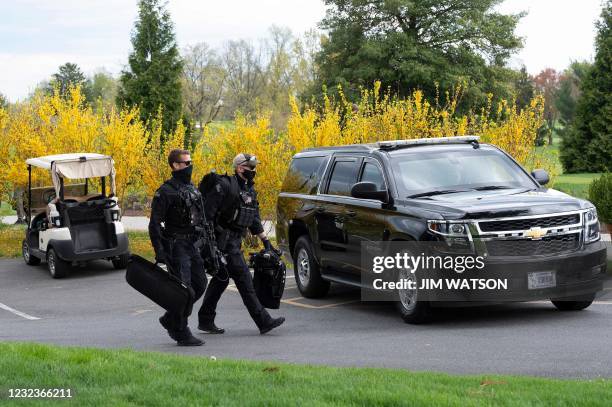 Secret Service officers walk the course as US President Joe Biden plays a round of golf at Wilmington Country Club in Wilmington, Delaware on April...