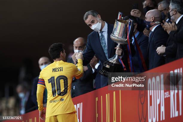 King Felipe VI gives the trophy to Lionel Messi of Barcelona after the Copa del Rey Final match between Athletic Club and Barcelona on April 17, 2021...