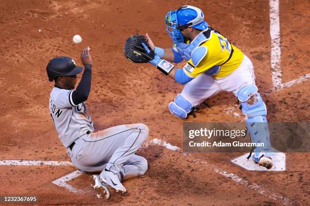 Tim Anderson of the Chicago White Sox slides toward home plate to score in the seventh inning as Kevin Plawecki of the Boston Red Sox waits for the...