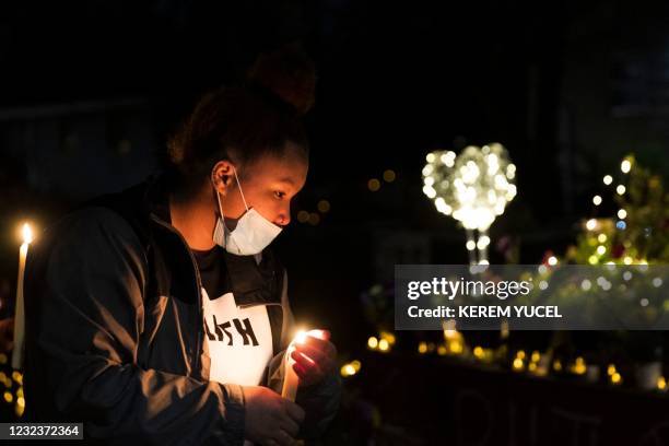 Daunte Wright's sister Diamond Wright lights candles at a vigil for her brother in Brooklyn Center, Minnesota on April 17, 2021. - Kim Potter, a...