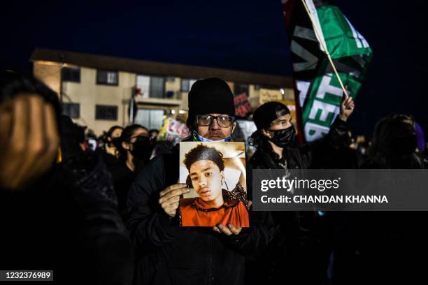 Demonstrator holds Daunte Wright's portrait during the seventh night of protests over the shooting death of Daunte Wright by a police officer in...