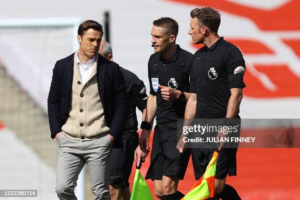 Fulham's English manager Scott Parker speaks with English referee Craig Pawson on the pitch after the English Premier League football match between...